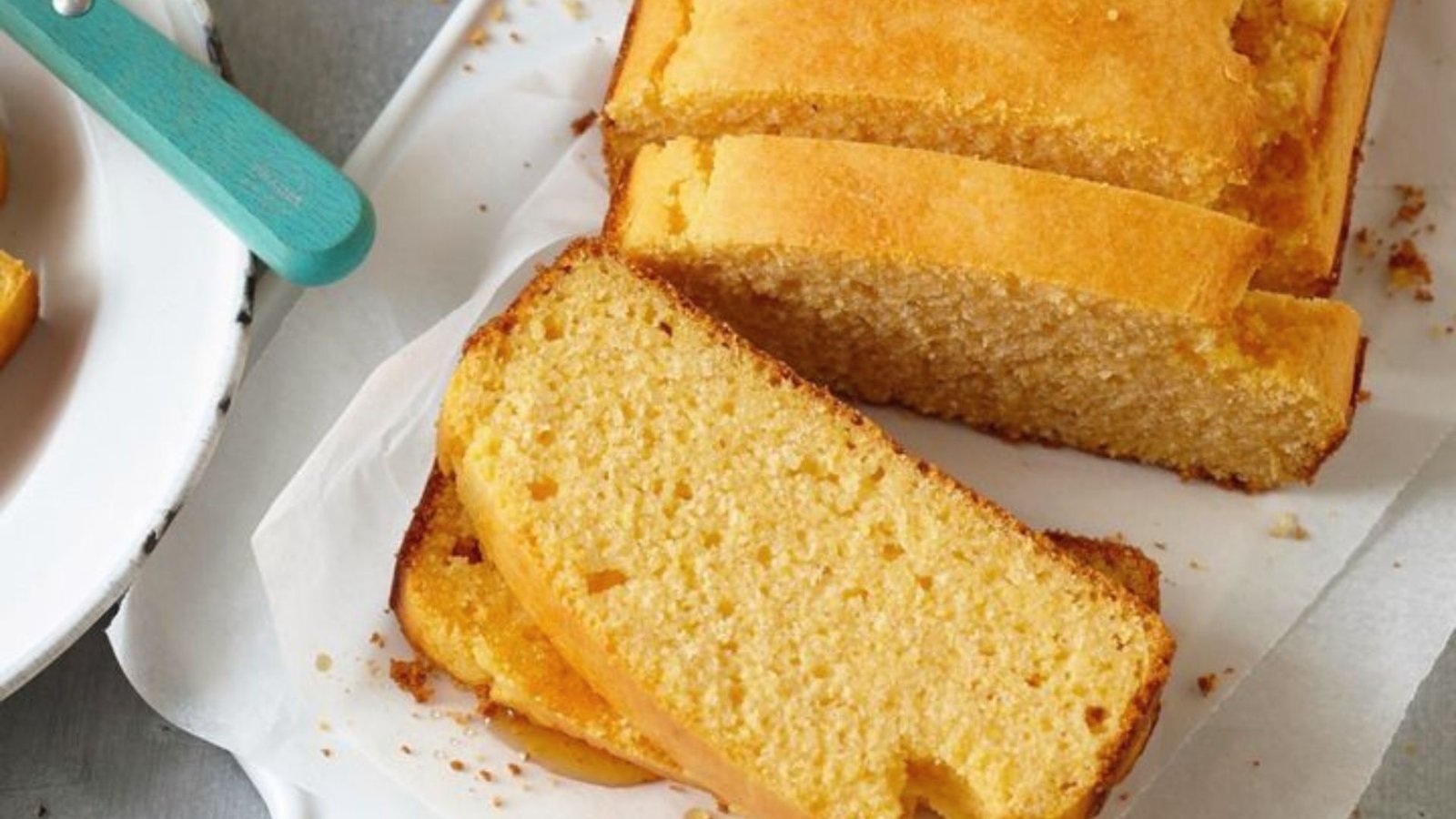 A loaf of cornbread with several slices cut out, showcasing its golden texture and fluffy interior.