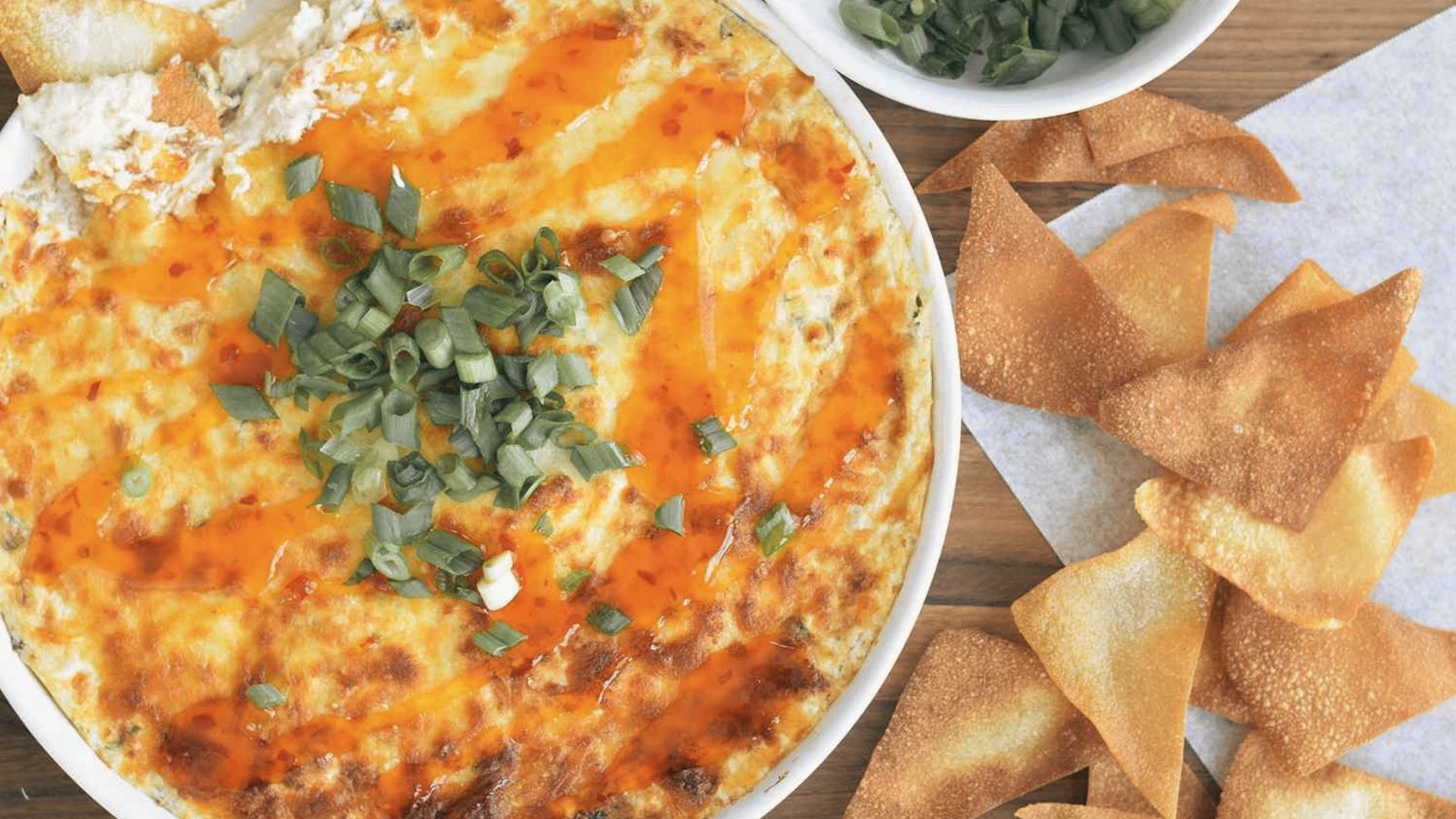 Cheesy crab rangoon dip served with tortilla chips in a bowl.