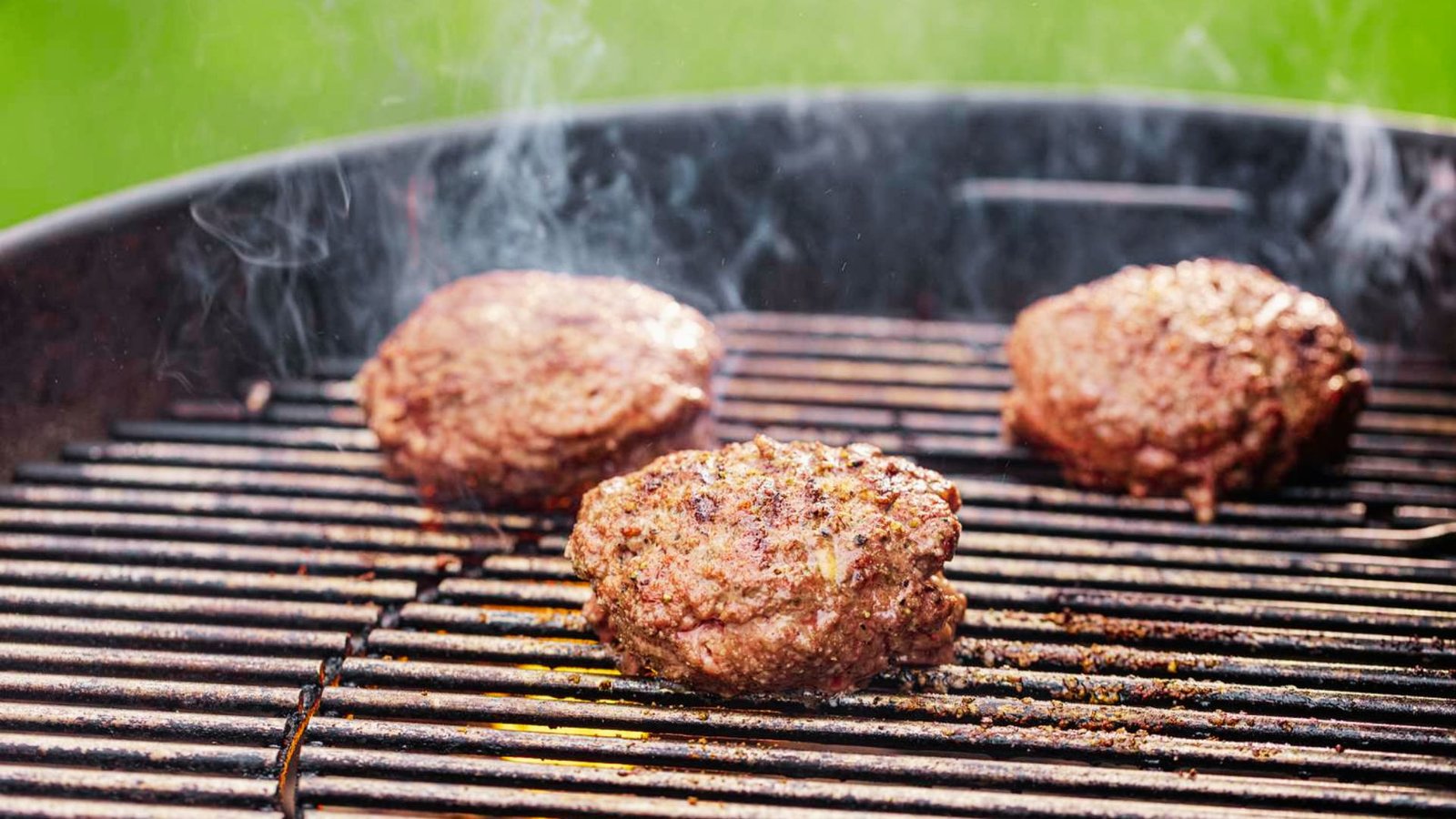 Three meatballs on a grill, showcasing a method for cooking ground beef for delicious burgers.