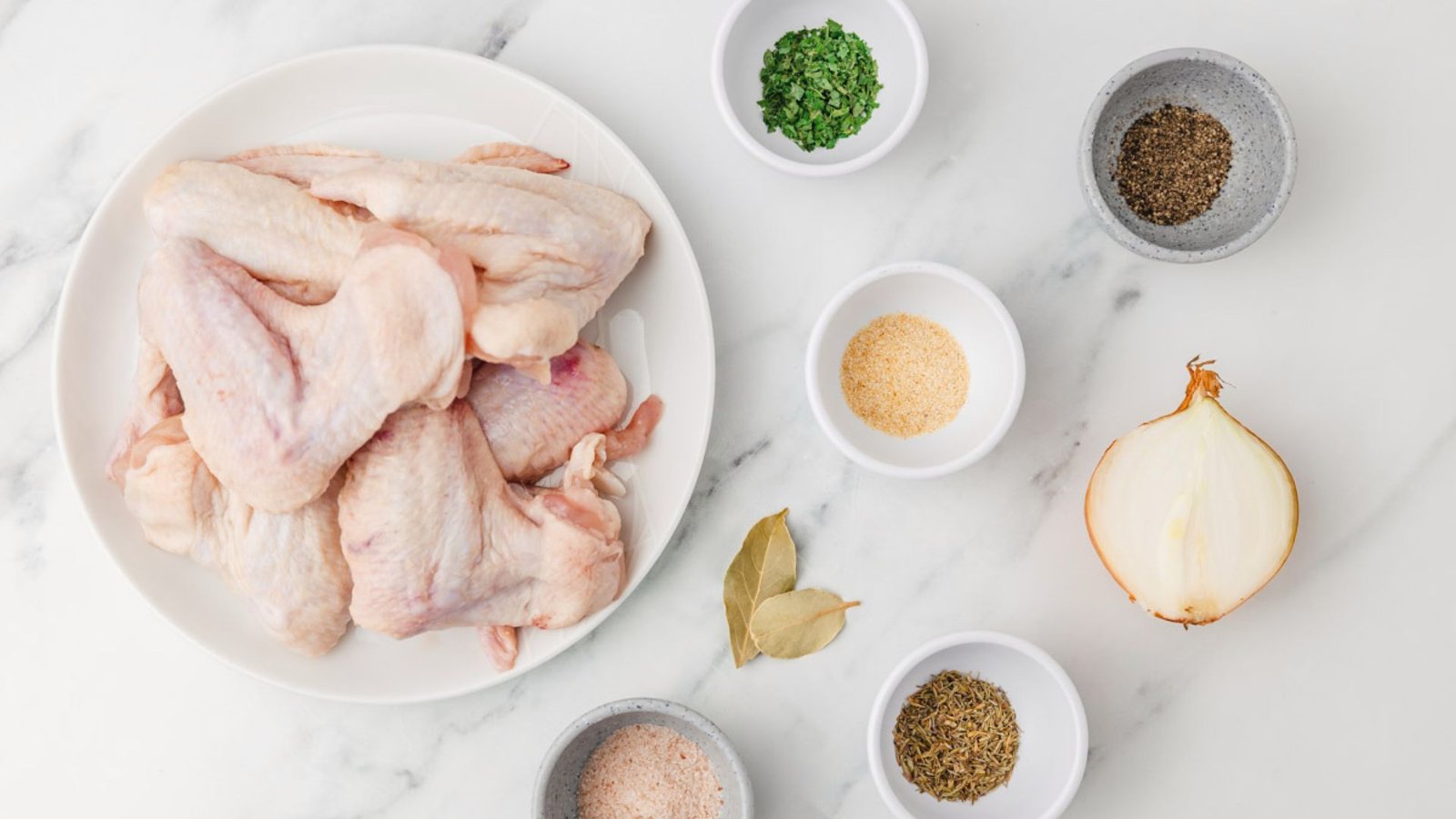Raw Chicken wings on a plate, with various spices and herbs, perfect for a chicken wing boil recipe.