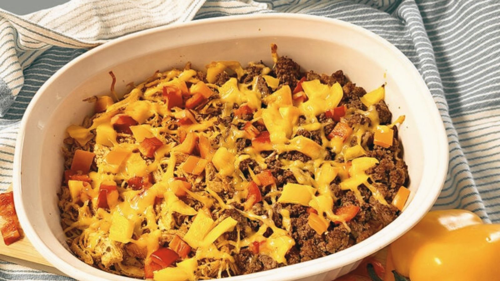 A casserole dish containing a mix of cheese and meat, illustrating a creative way to repurpose leftover taco meat.
