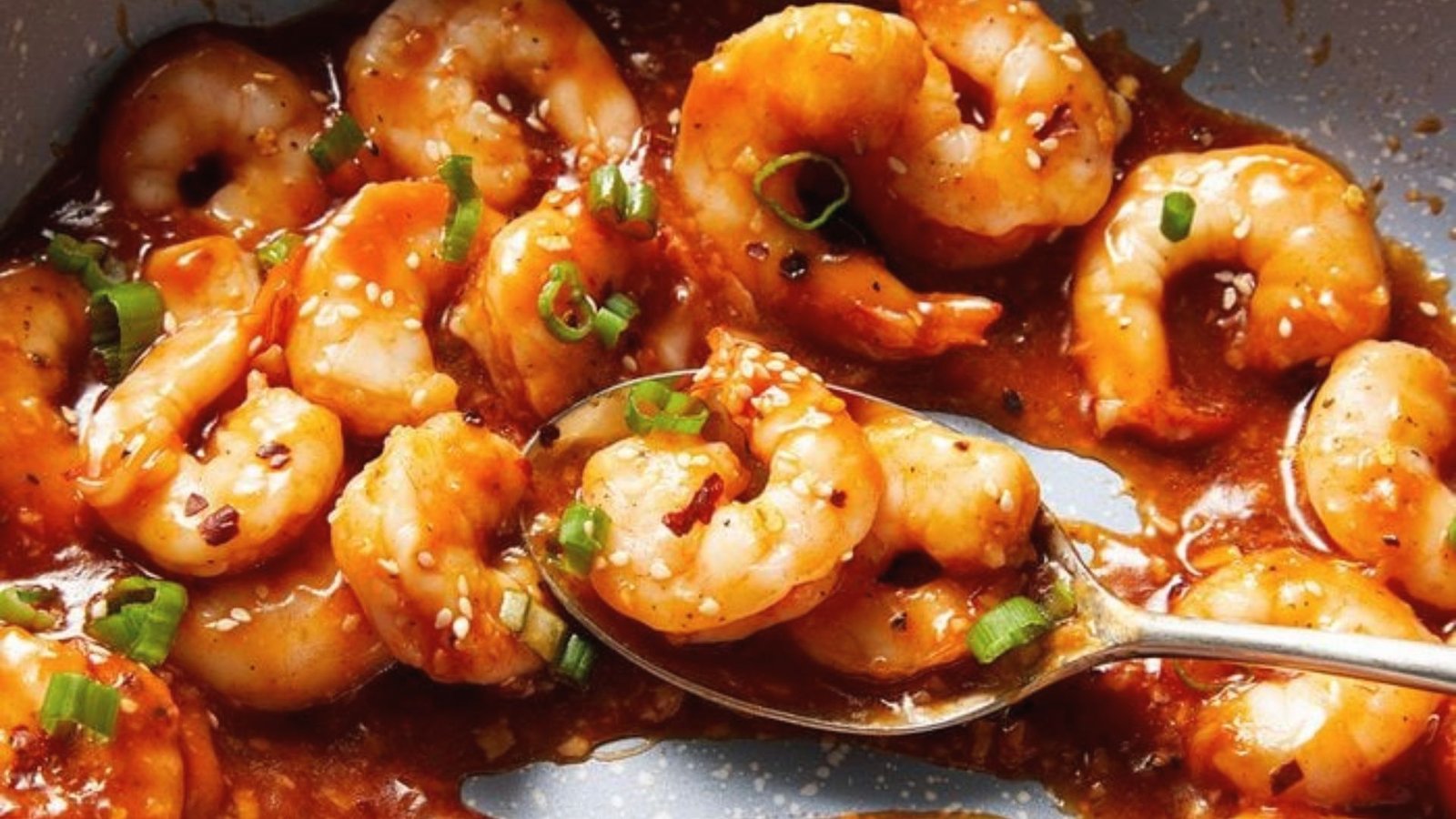A pan filled with shrimp and crab in a savory sauce, ready to be served.