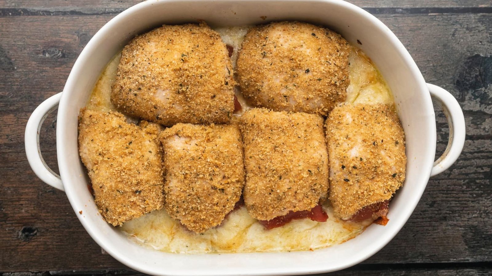 Baked chicken Rollatini in a white casserole dish, golden and juicy, ready to be served.