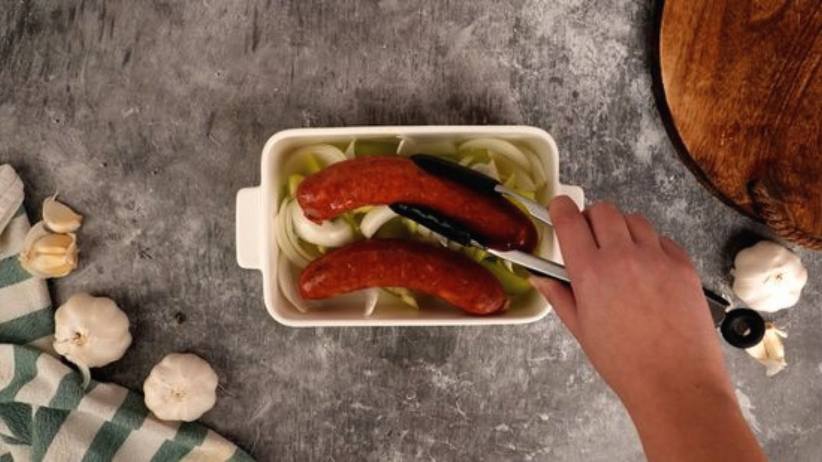 A person slices homemade deer sausage in a bowl, highlighting the preparation of popular recipes.