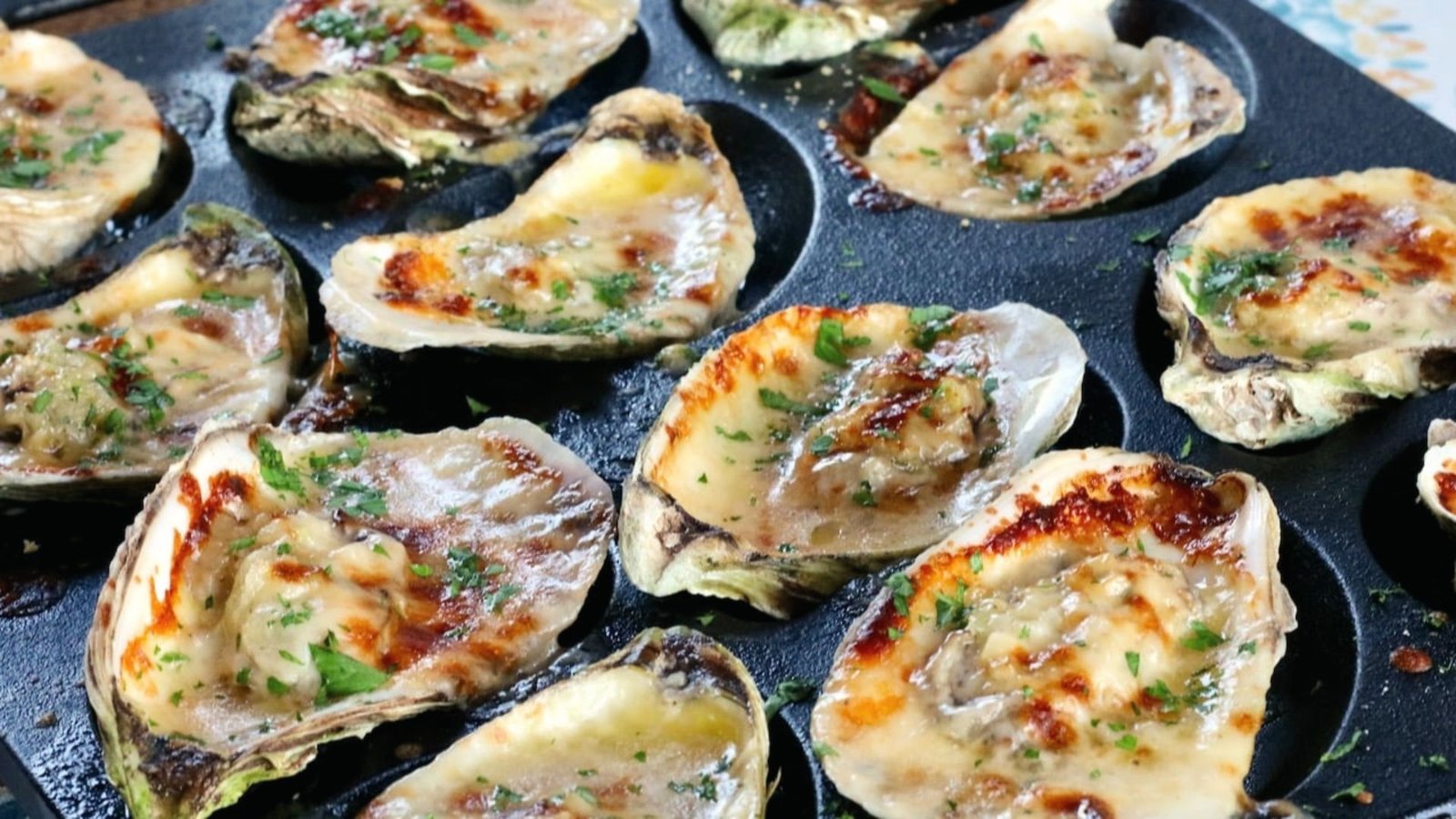 Baked oysters topped with creamy spinach, golden and crispy, ready to be served.