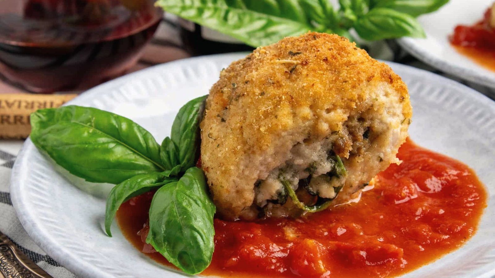 A plate featuring a Chicken Rollatini with rich sauce.