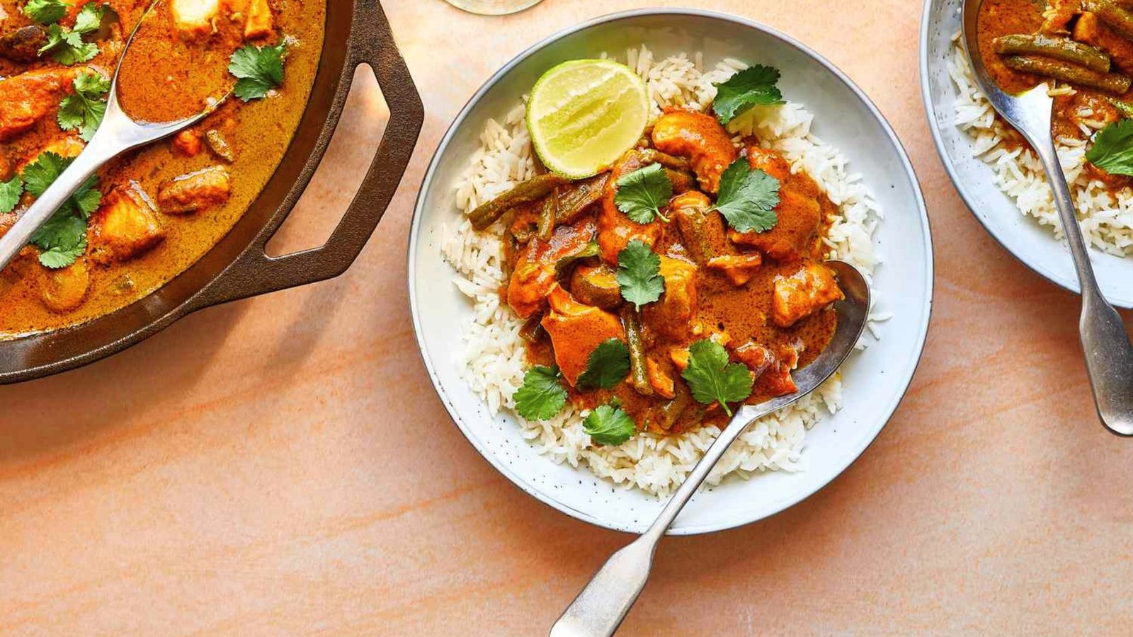 A table set with two plates of rice and curry, ideal for serving alongside a Thai fish dish.