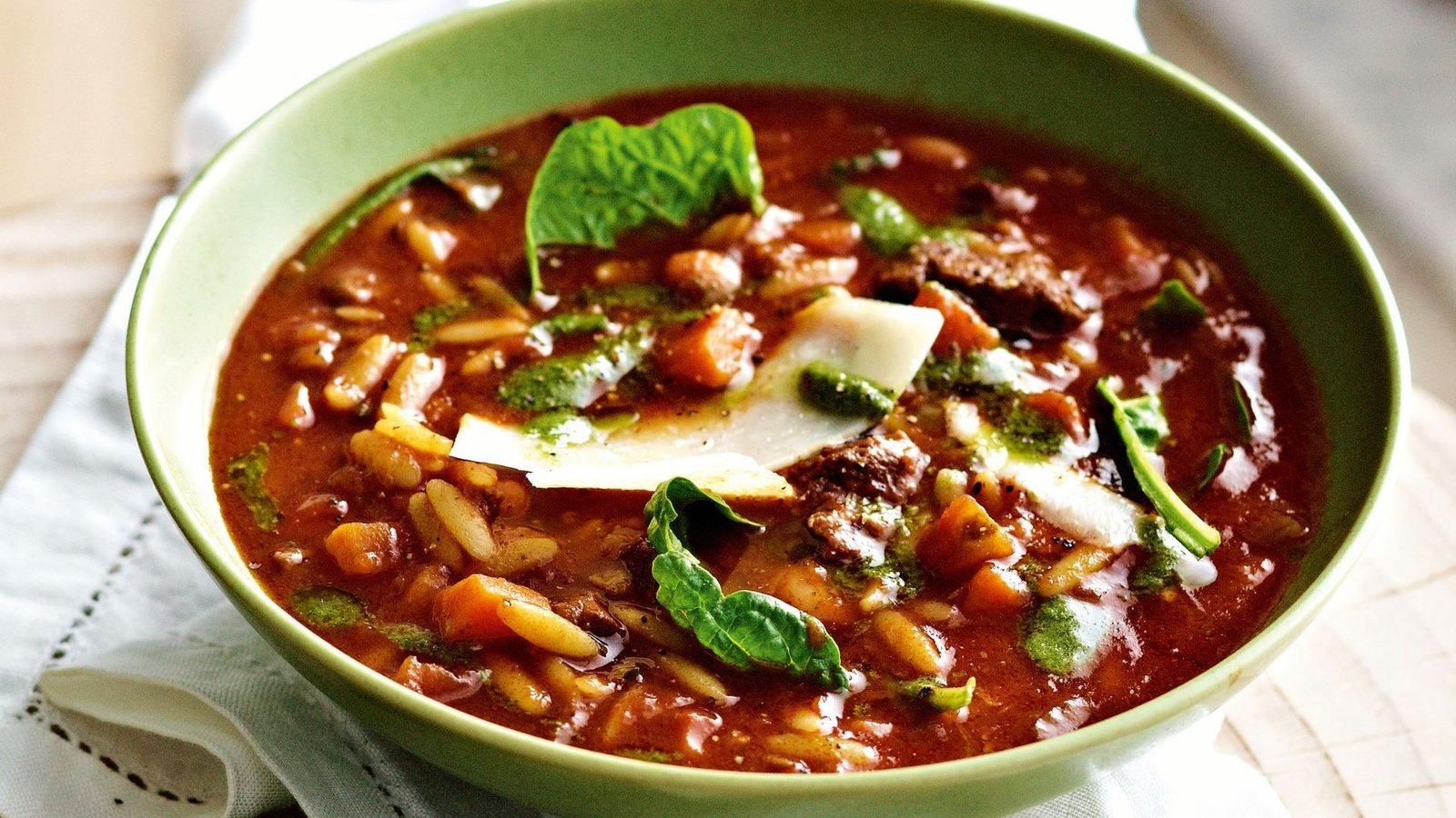 A bowl of beef minestrone soup filled with colorful vegetables, ready to be enjoyed at home.