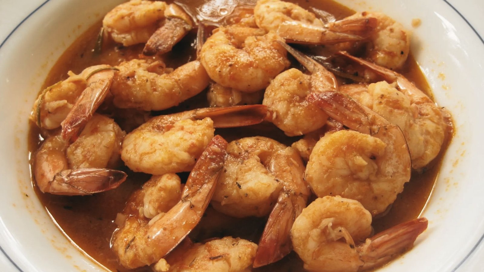 A bowl of shrimp coated in a savory sauce, representing the Original Killer Shrimp recipe from Marina Del Rey.