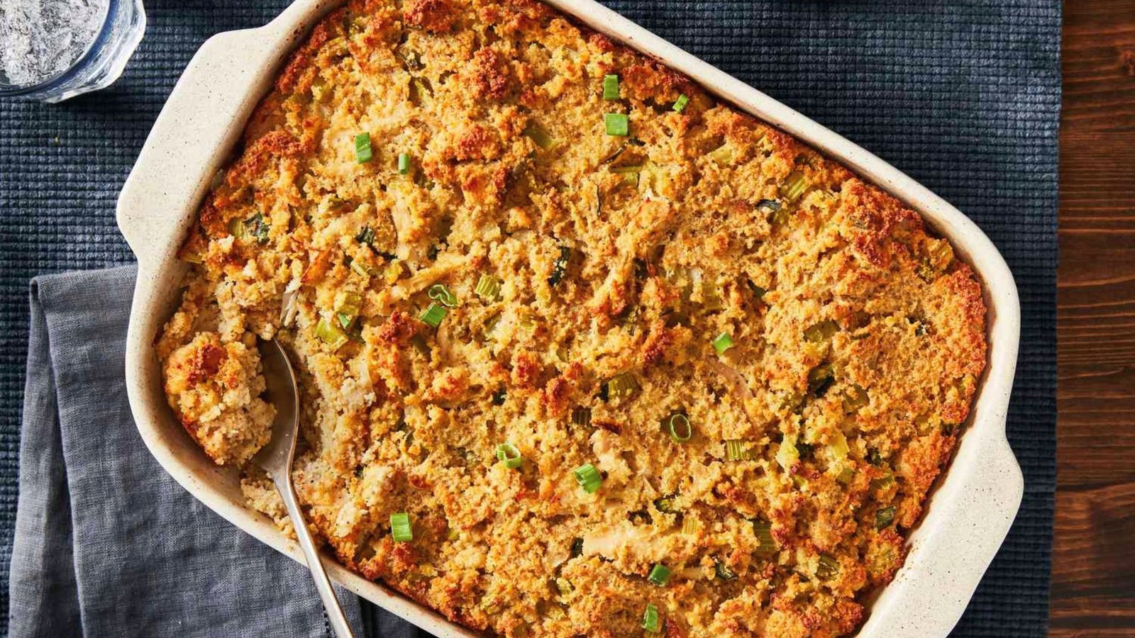 A Southern Chicken Dressing dish filled with golden cornbread topped with chopped green onions.