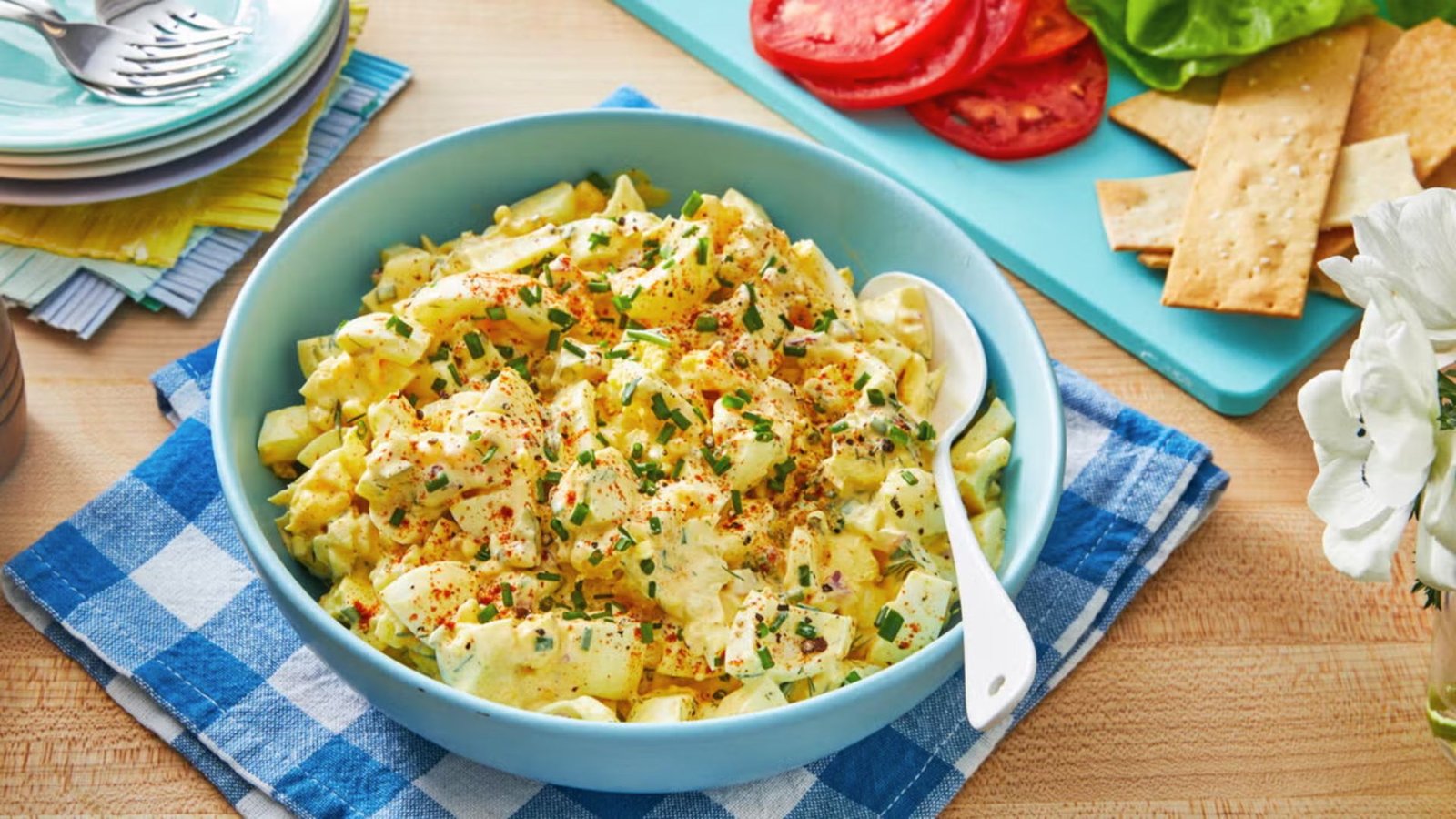 A bowl featuring egg salad with pickles ready to get chilled.