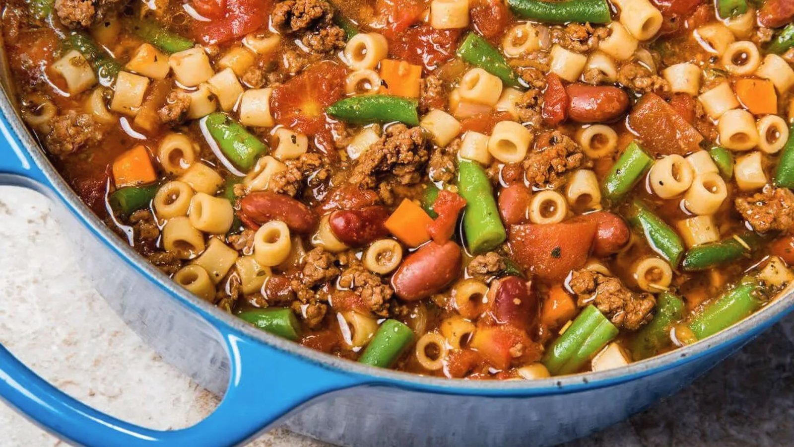 A hearty pot of beef minestrone soup featuring pasta, tender meat, and assorted vegetables.