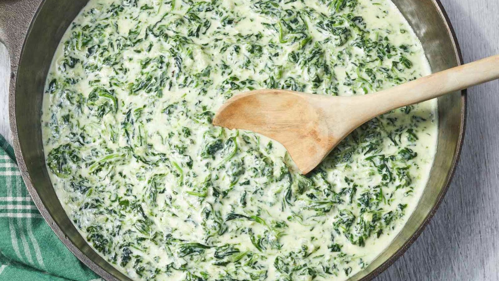 A pan filled with creamy spinach dip, showcasing a smooth mixture of spinach and flavorful ingredients.