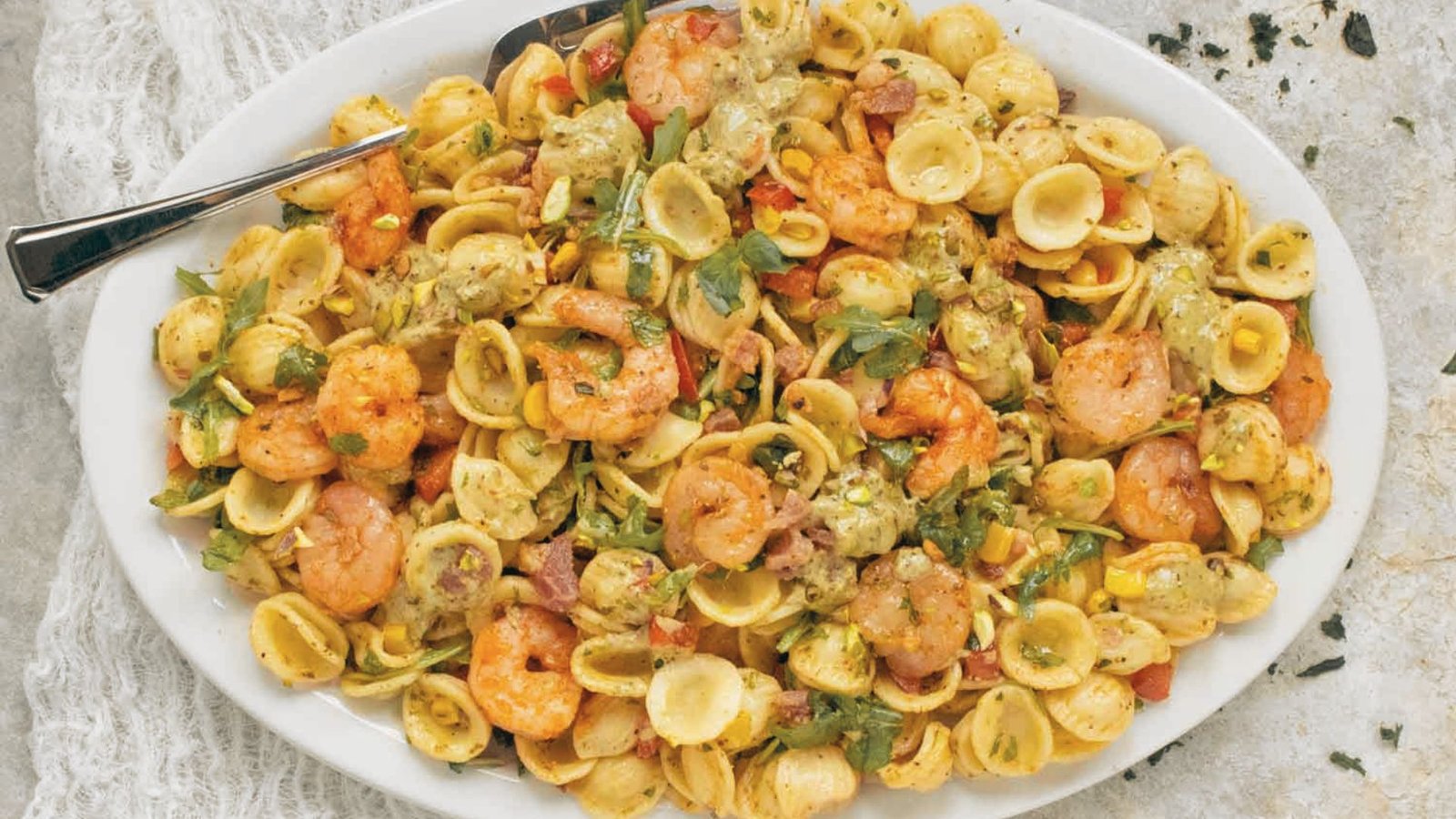 A plate of shrimp pasta salad featuring colorful vegetables and succulent shrimp, highlighting a delicious recipe.