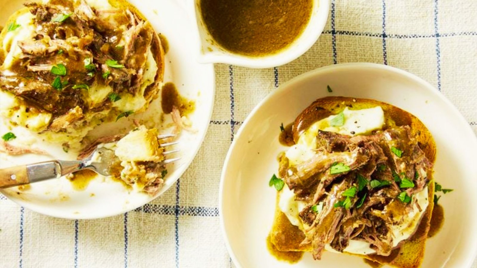 Two plates of turkey Manhattan, each topped with savory meat and rich gravy, showcasing a popular recipe.