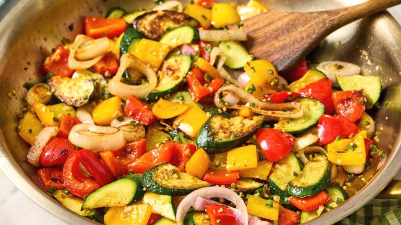 A pan filled with sautéed vegetables and onions, for creating a flavorful base in cooking.