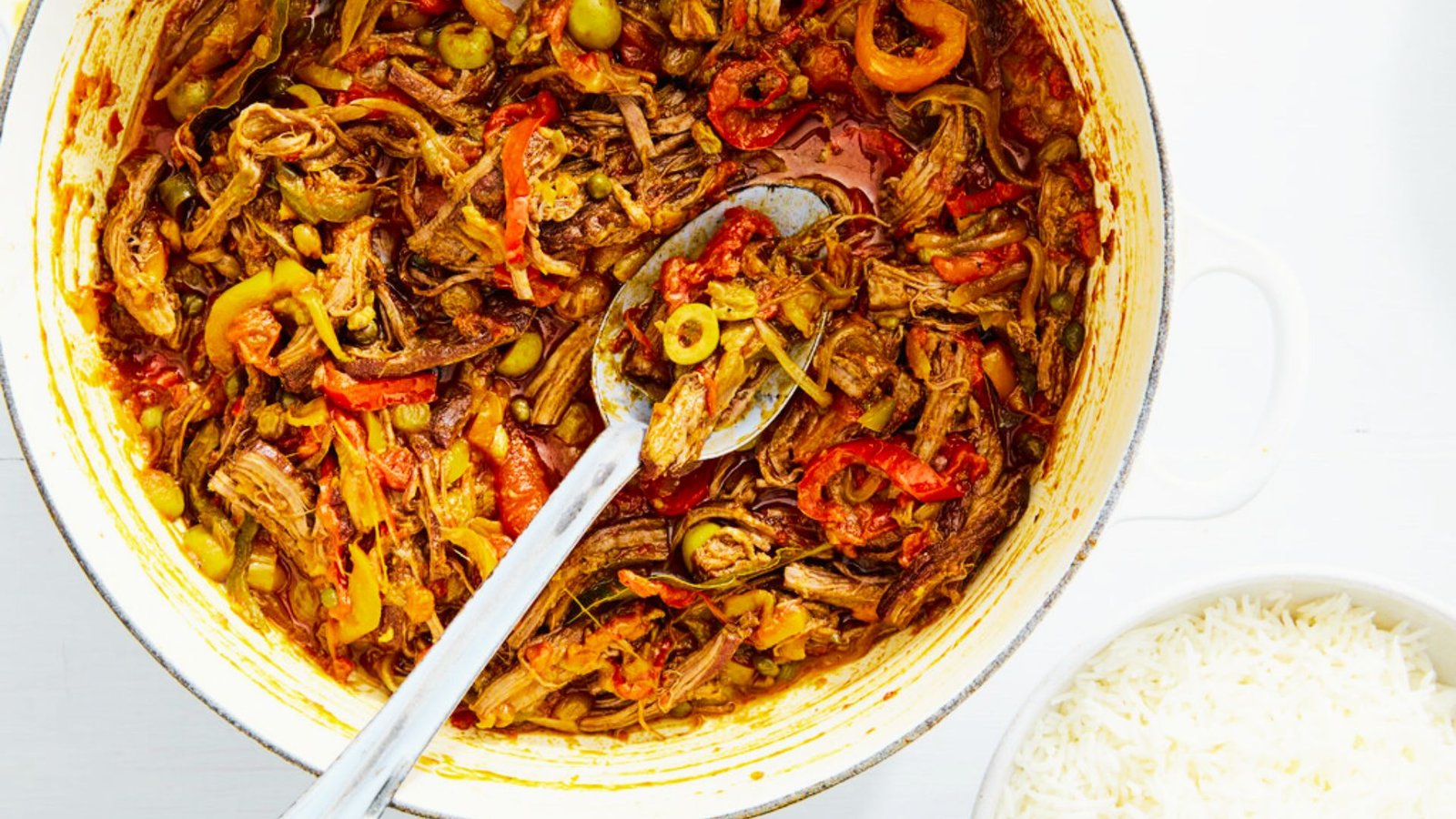 A white bowl filled with Ropa Vieja, showcasing tender meat and colorful vegetables, representing home cooking basics.