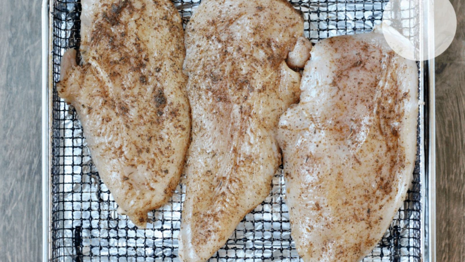 Three pieces of fish arranged on a baking sheet, ready for seasoning before cooking.