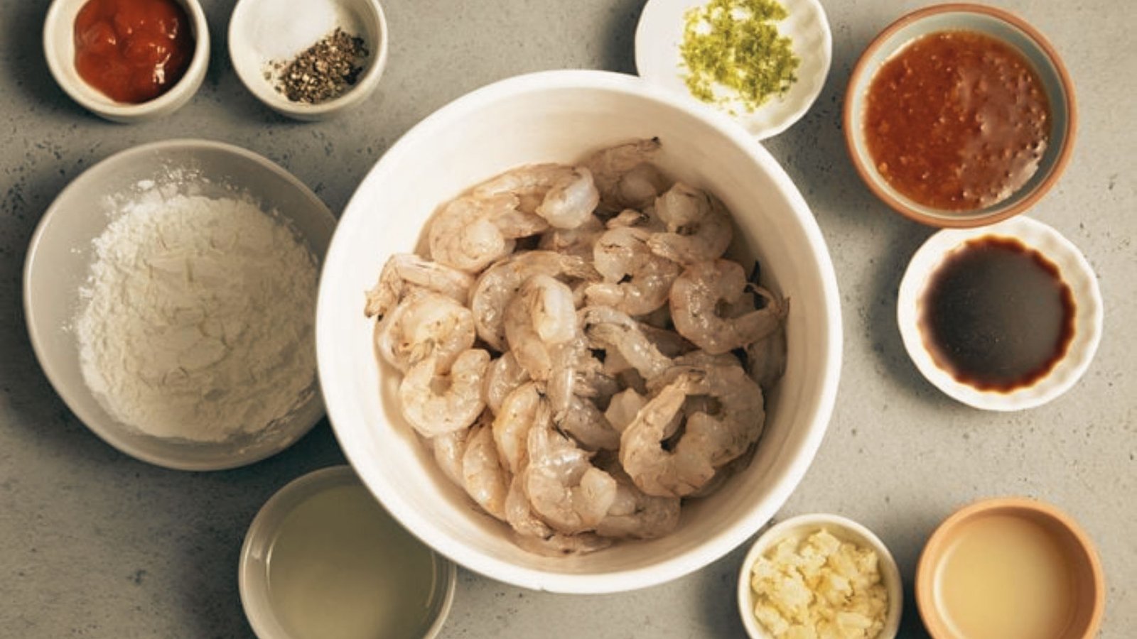 Bowls filled with ingredients for a Killer Shrimp recipe, influenced by Marina Del Rey style cooking at home.