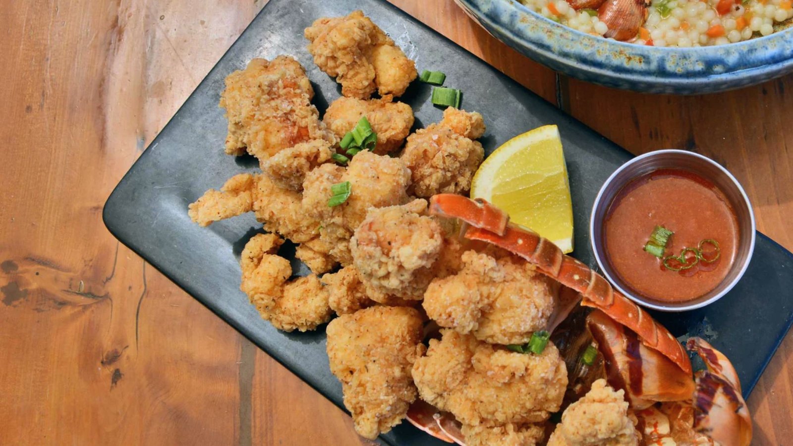 A plate of golden, crispy shrimp alongside a bowl of fluffy rice, showcasing a delicious Lobster Bites recipe.