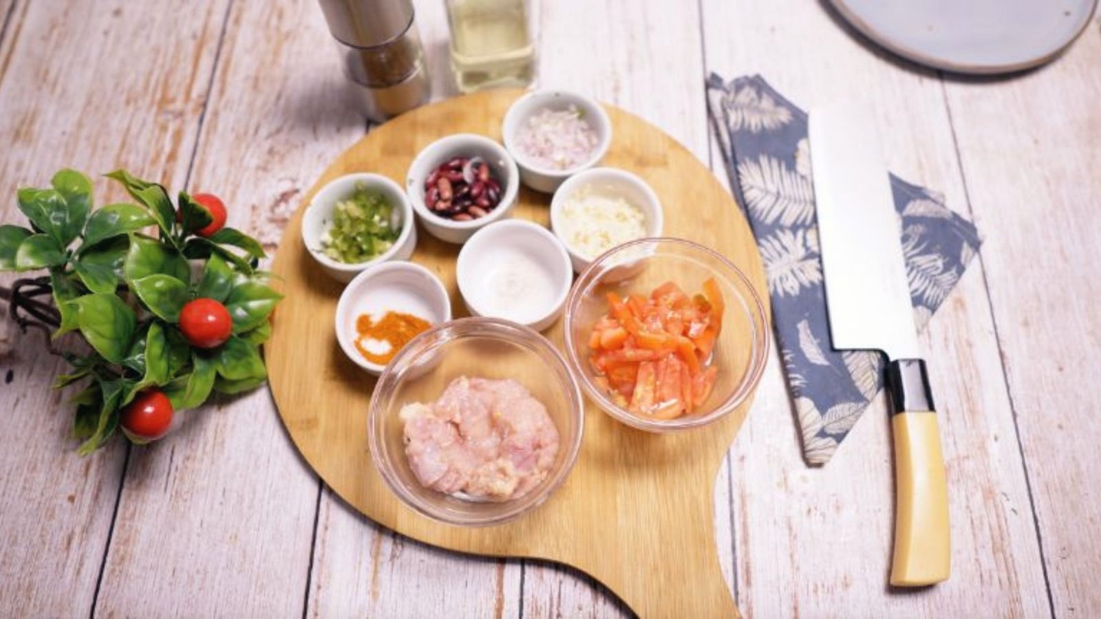 Ingredients for Barefoot Contessa Turkey Chili displayed on a wooden cutting board, including vegetables and seasonings.