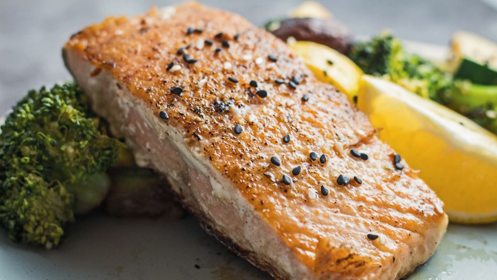 Hibachi salmon served with vibrant vegetables on a wooden table, showcasing a Japanese steakhouse dish.