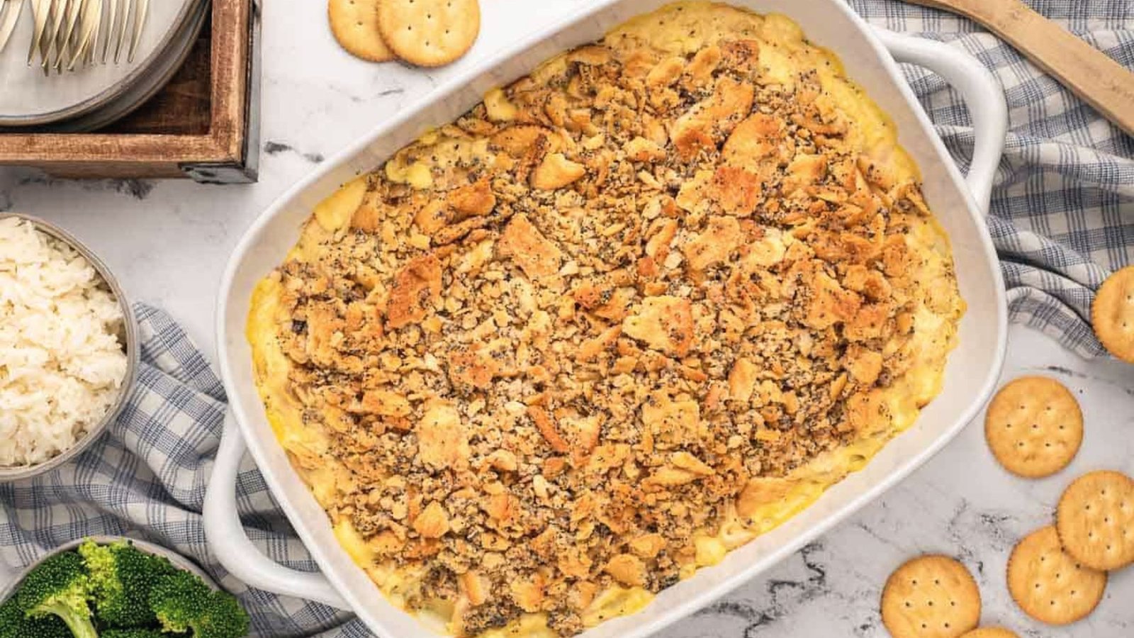 A casserole dish filled with poppyseed chicken golden-brown crackers and melted cheese.
