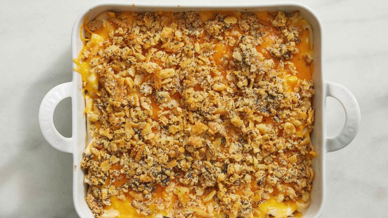 A casserole dish showcasing a cheesy poppyseed chicken recipe.