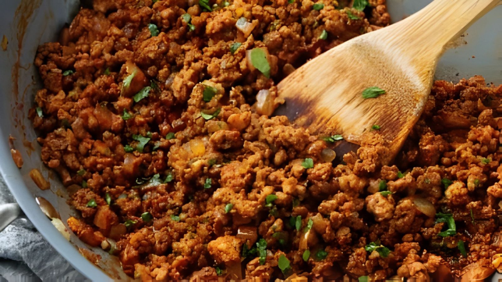 A pan filled with chili and meat, ready to be improved with garlic, spices, and seasonings.