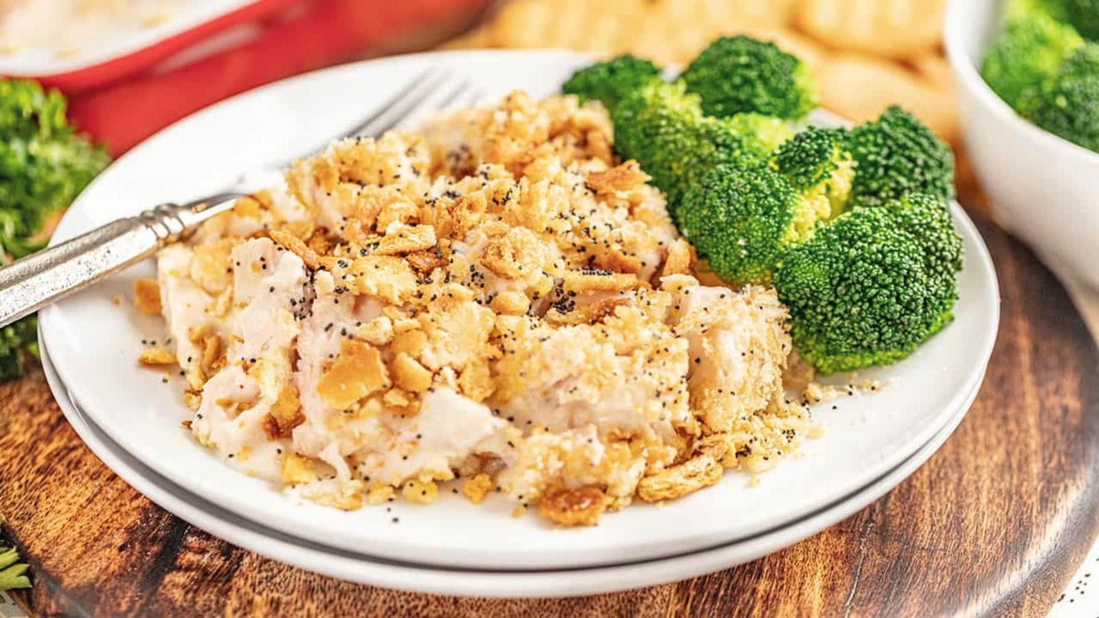 Chicken casserole topped with crackers, served with broccoli, ideal for pairing with poppyseed chicken recipe.
