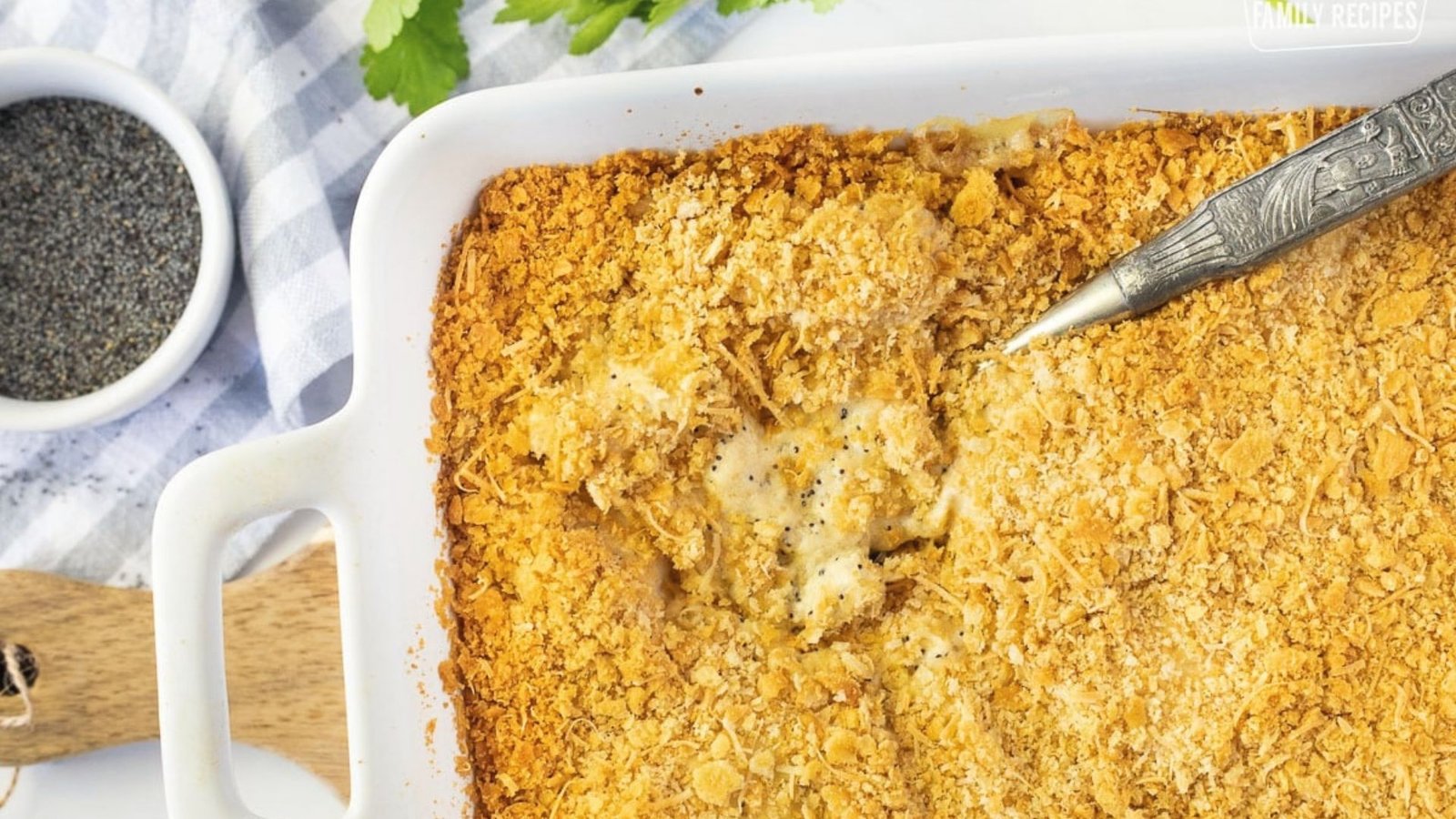 Creamy baked chicken casserole garnished with cheese and herbs, showcasing a golden, bubbly top.